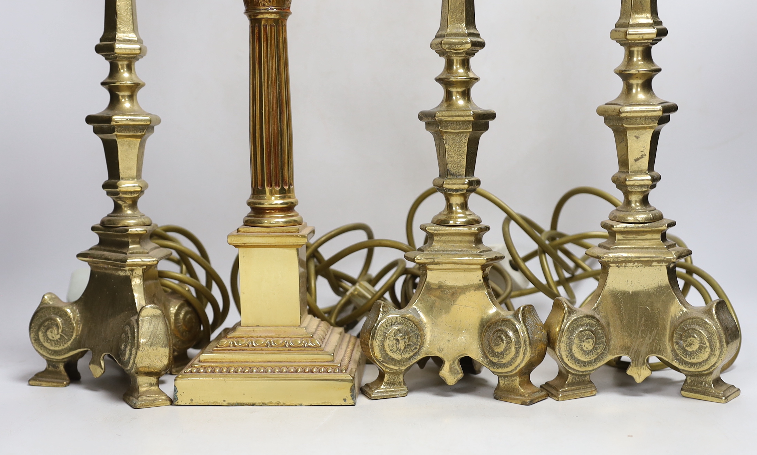 Four brass column lamps including a set of three, largest each 44cm high